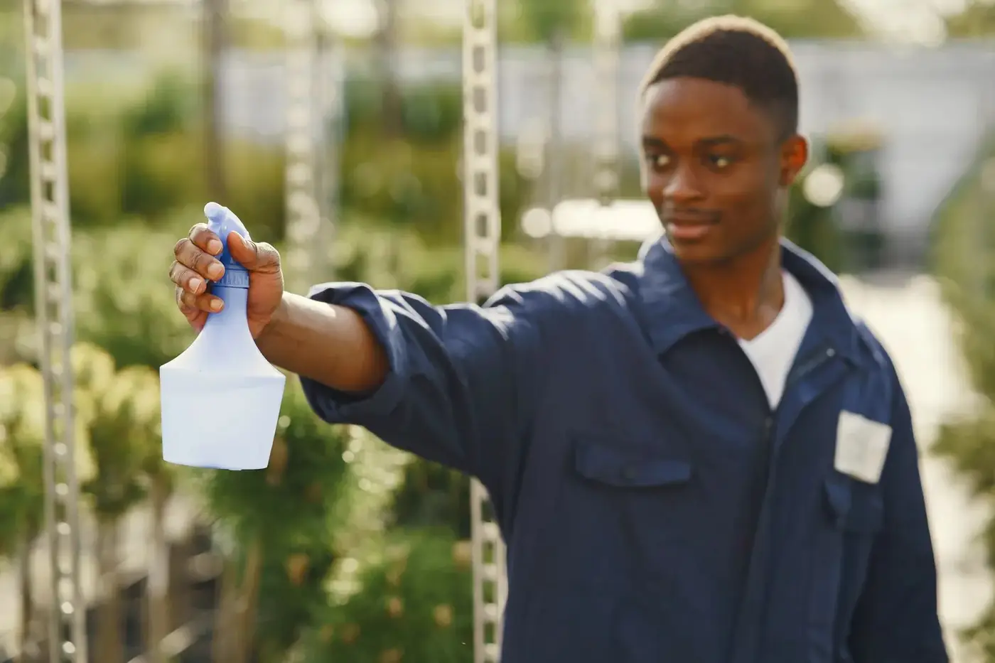 Technician applying an eco-friendly treatment inside a greenhouse